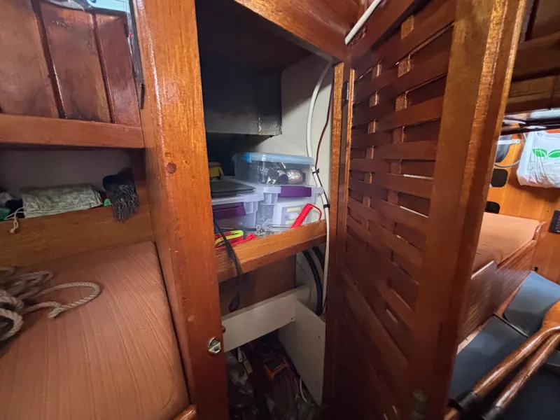 Interior storage of 1975 Custom 45’ Thomas Colvin “Tamarack” Schooner with wooden cabinetry.