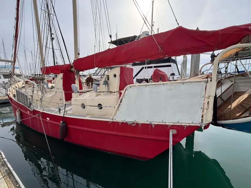 Red and white 1975 Custom 45’ Thomas Colvin “Tamarack” Schooner docked at marina.