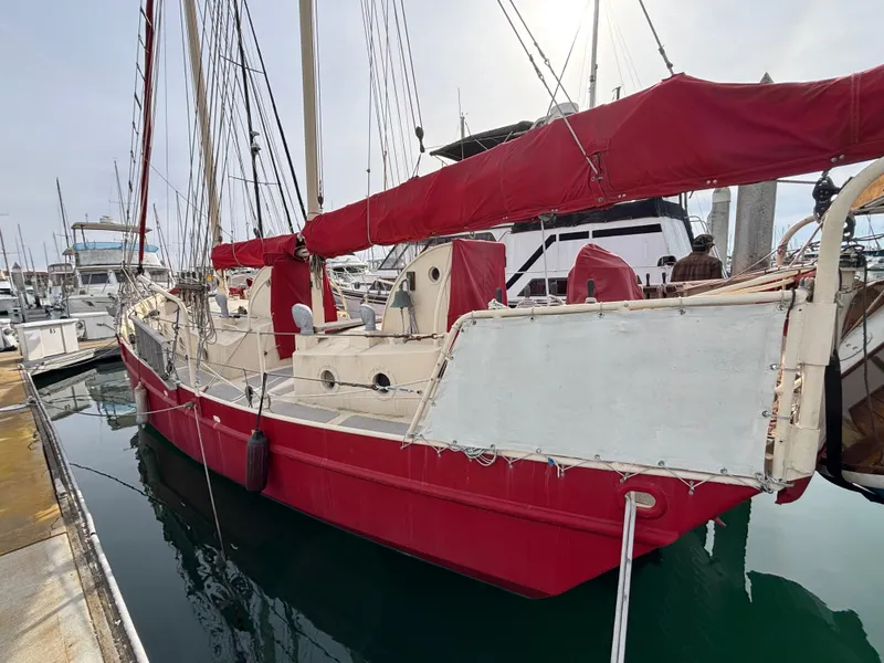 Red 1975 Custom 45’ Thomas Colvin “Tamarack” Schooner docked in marina.