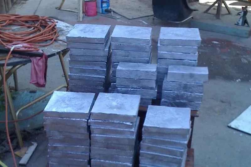 Stacks of metal blocks on a workshop floor, near a Custom 45’ Thomas Colvin “Tamarack” Schooner.