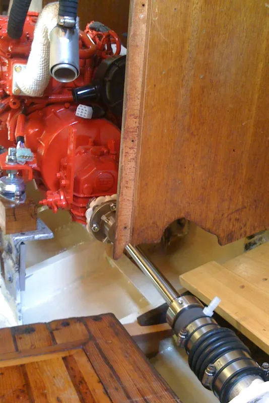 Engine room of 1975 Custom 45’ Thomas Colvin “Tamarack” Schooner, featuring red engine and wooden interior.
