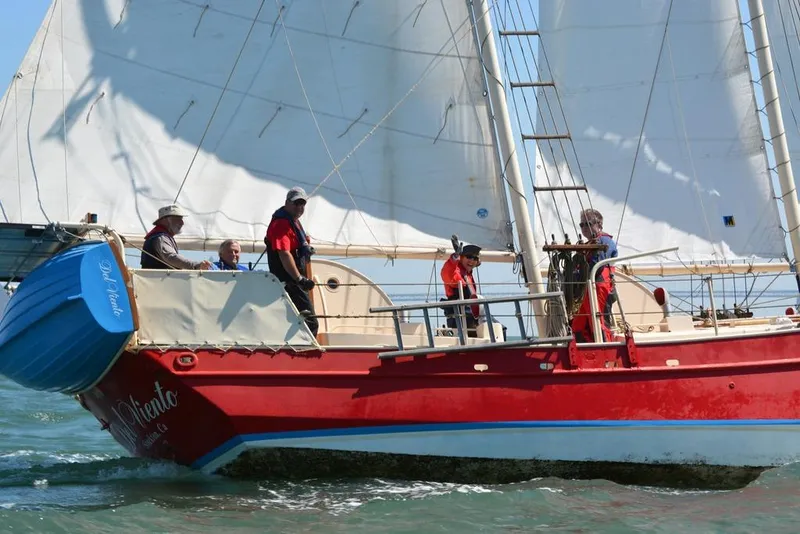 Red 1975 Custom 45’ Thomas Colvin “Tamarack” Schooner sailing with crew on a sunny day.