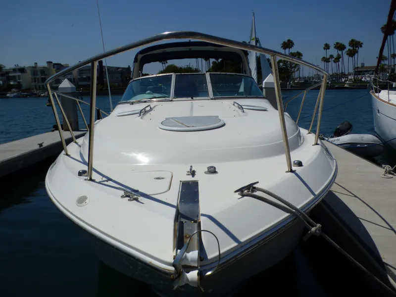2001 Monterey 302 Cruiser docked at marina, sunny day, calm water, palm trees in background.