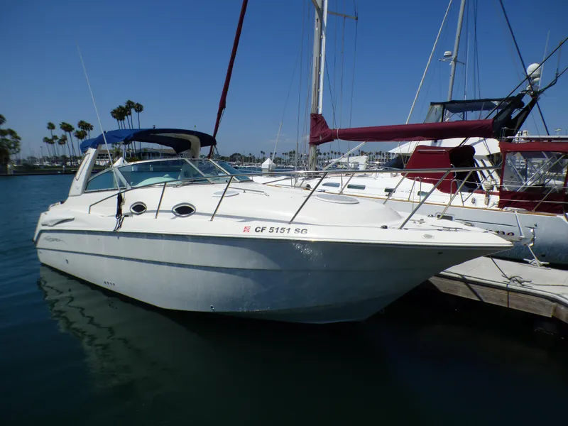 2001 Monterey 302 Cruiser docked in a marina under clear blue skies.