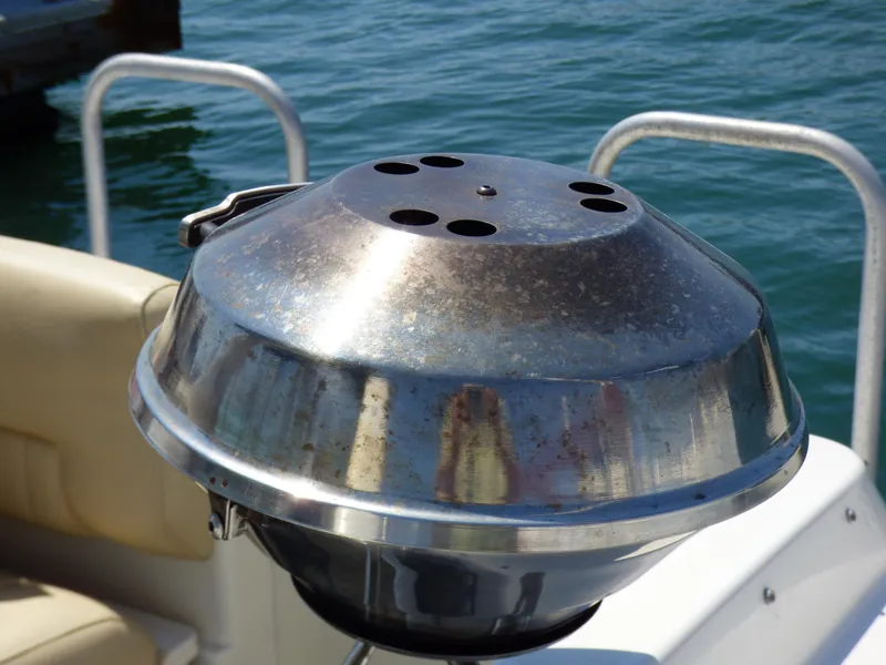 Stainless steel grill on a 2001 Monterey 302 Cruiser boat by the water.