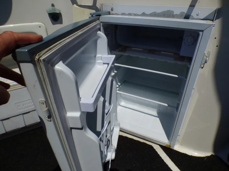 Open refrigerator on a 2001 Monterey 302 Cruiser boat, showing interior shelves.