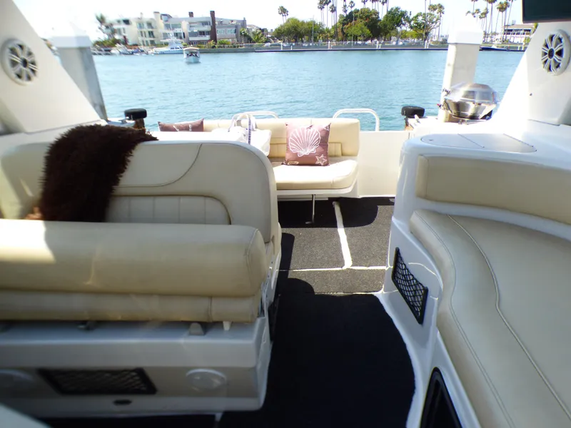 2001 Monterey 302 Cruiser interior with beige seating, overlooking a scenic waterfront.