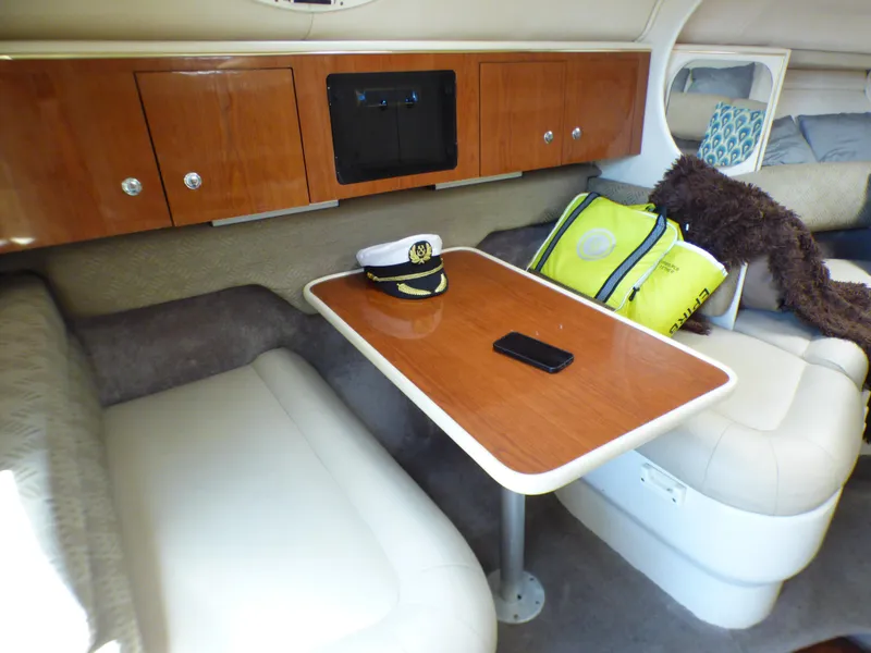 Interior of 2001 Monterey 302 Cruiser with table, captain's hat, and seating.