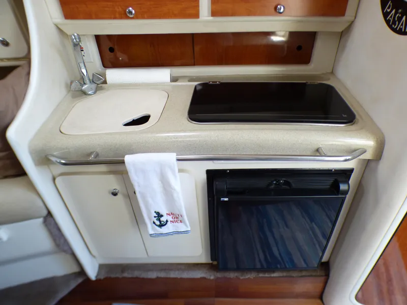 Compact kitchen area in a 2001 Monterey 302 Cruiser boat, featuring a sink and mini fridge.