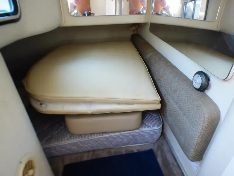 Interior cabin of 2001 Monterey 302 Cruiser with cushioned seating and bedding.