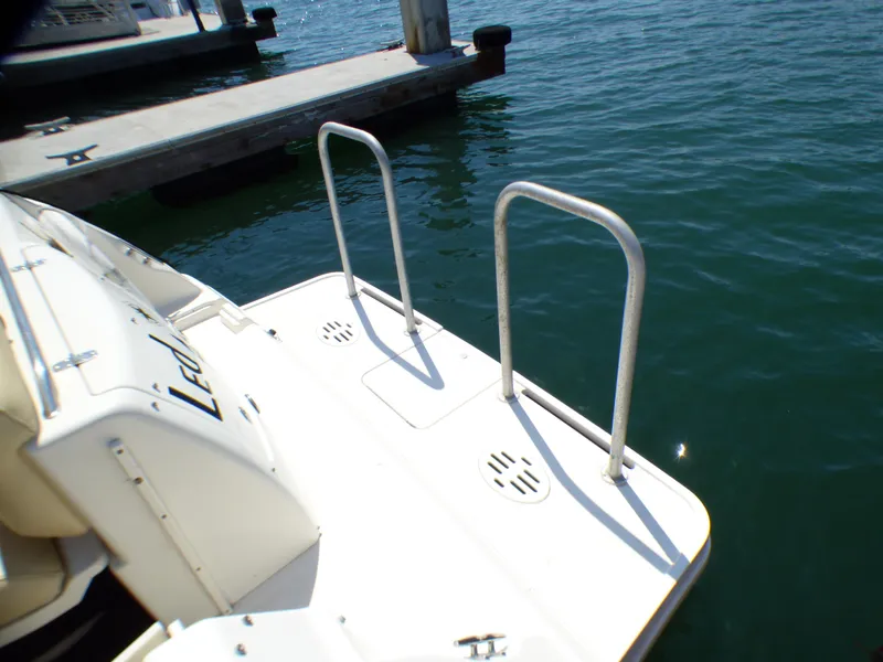 2001 Monterey 302 Cruiser swim platform with ladder, docked on calm water.