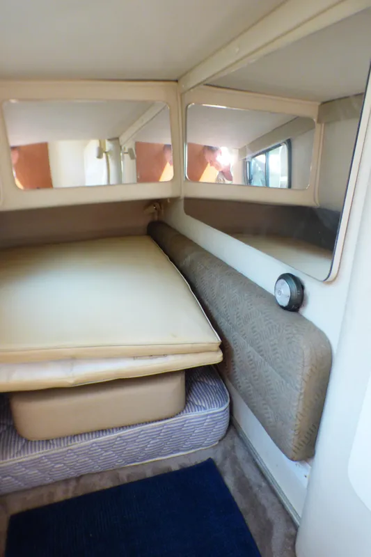 2001 Monterey 302 Cruiser cabin interior with bed, mirrors, and cushioned seating.