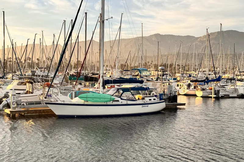 1979 O'Day 37 Center Cockpit sailboat docked in a marina at sunset.