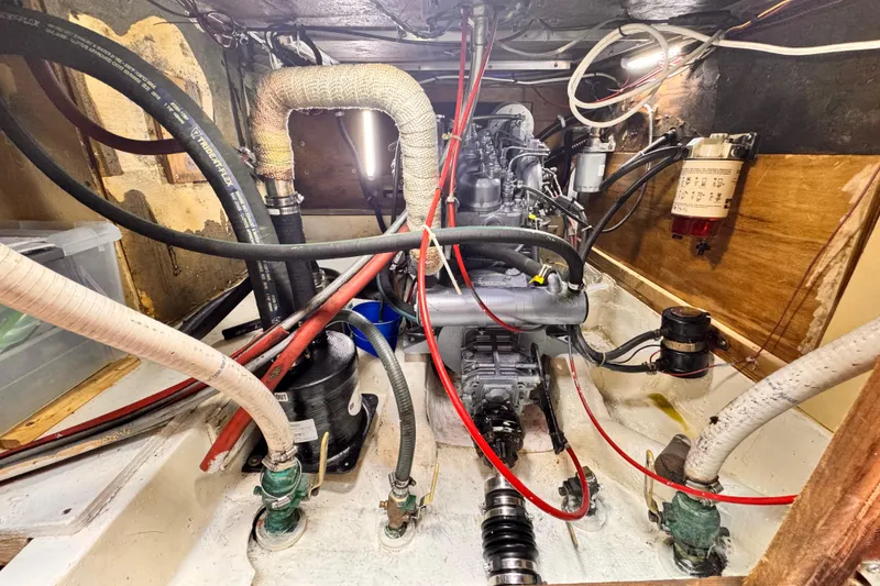 Engine compartment of a 1979 O'Day 37 Center Cockpit sailboat, showing hoses and components.
