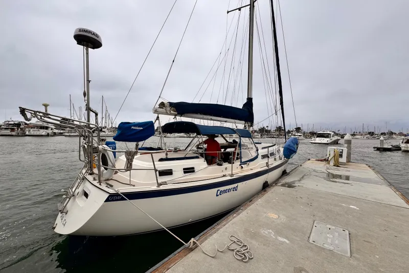 1979 O'Day 37 Center Cockpit sailboat docked at a marina on a cloudy day.