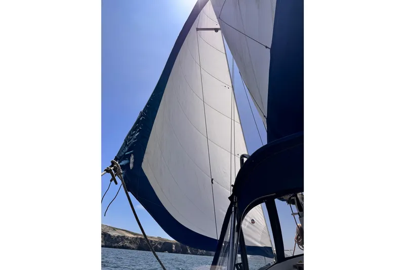 Sailing on a 1979 O'Day 37 Center Cockpit with full sails under clear blue skies.