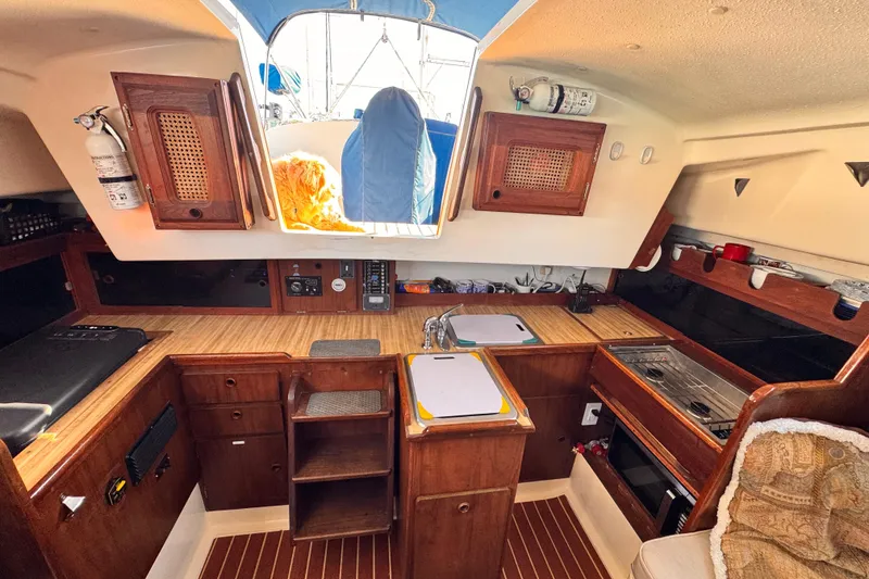 1979 O'Day 37 Center Cockpit interior with wooden cabinetry and kitchen area.