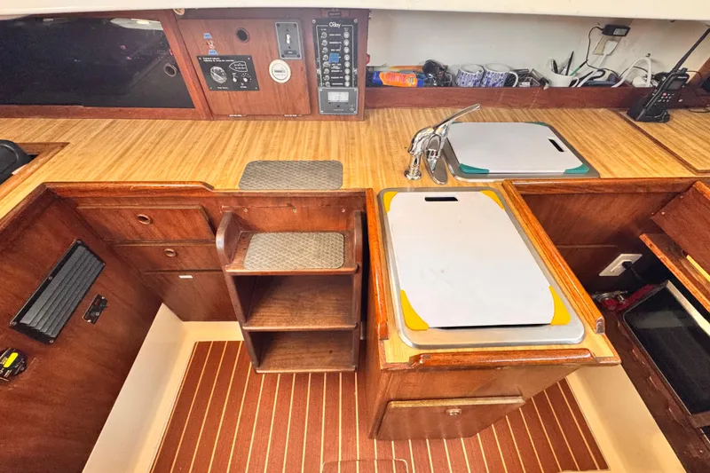 1979 O'Day 37 Center Cockpit interior with wooden cabinetry and kitchen sink.