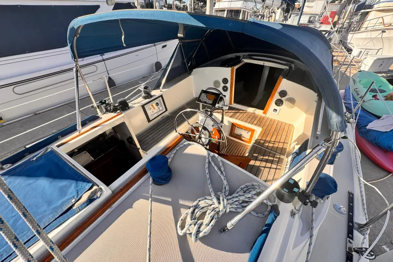 1979 O'Day 37 Center Cockpit sailboat with blue canopy and wooden deck details.