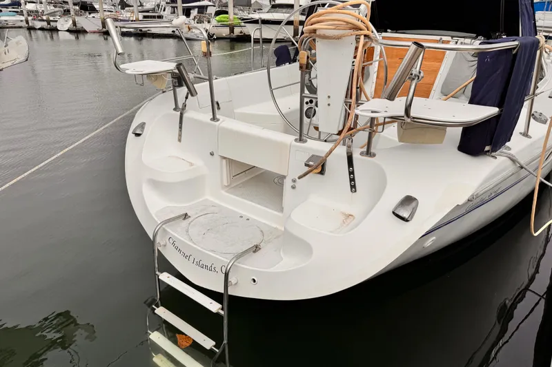 Catalina 36 MkII 2001 sailboat docked at marina, featuring swim ladder and cockpit area.