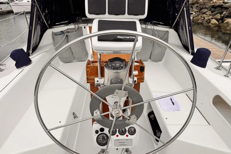 Steering wheel and cockpit of 2001 Catalina 36 MkII sailboat with navigation equipment.