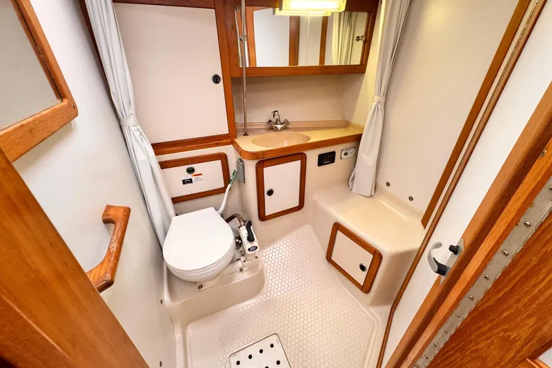 2001 Catalina 36 MkII yacht bathroom with toilet, sink, and wooden cabinetry.