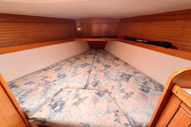 Cozy V-berth cabin in 2001 Catalina 36 MkII sailboat with patterned cushions.