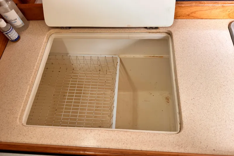 Empty storage compartment on 2001 Catalina 36 MkII sailboat with wire rack.