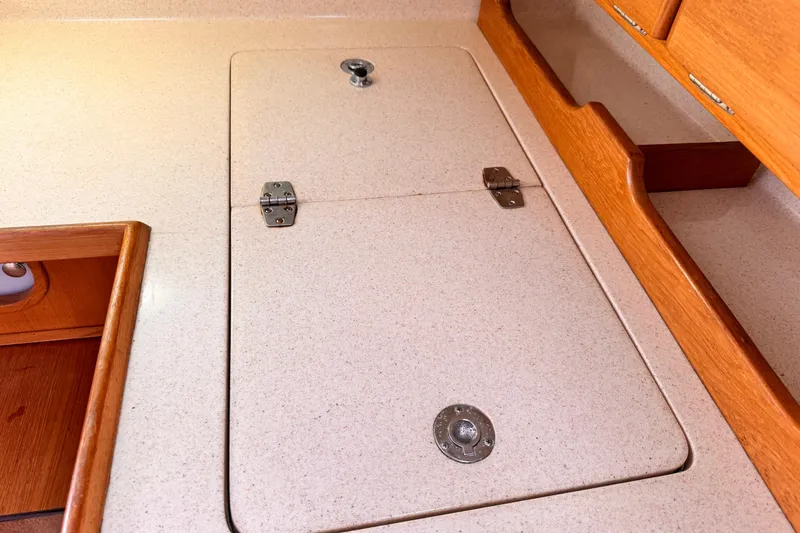 Interior of 2001 Catalina 36 MkII sailboat with wooden cabinetry and storage compartment.
