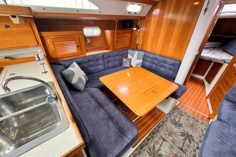 Interior of 2001 Catalina 36 MkII sailboat with cozy seating and wooden table.