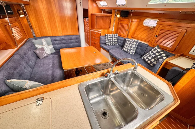 Interior of 2001 Catalina 36 MkII sailboat with cozy seating and wooden finishes.