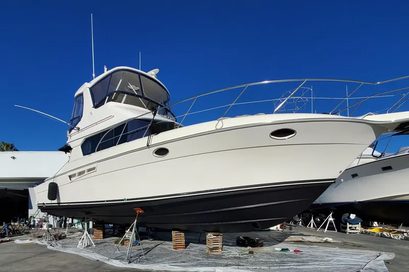 2000 Silverton 42 Convertible yacht on dry dock under clear blue sky.