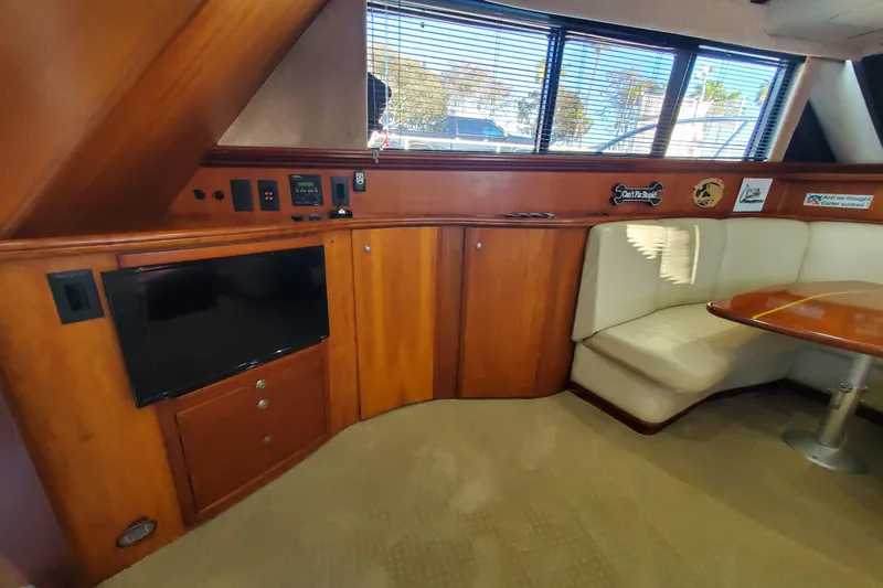 Interior of 2000 Silverton 42 Convertible yacht with wood cabinetry and seating area.