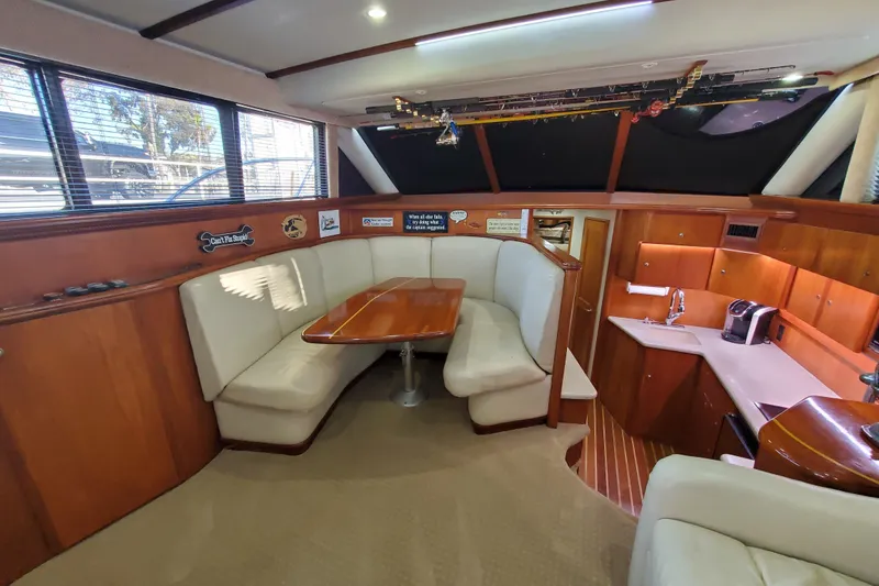 Interior of 2000 Silverton 42 Convertible yacht with dining area and kitchenette.