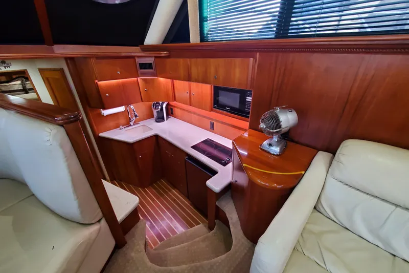 Interior of 2000 Silverton 42 Convertible yacht with compact kitchen and seating area.