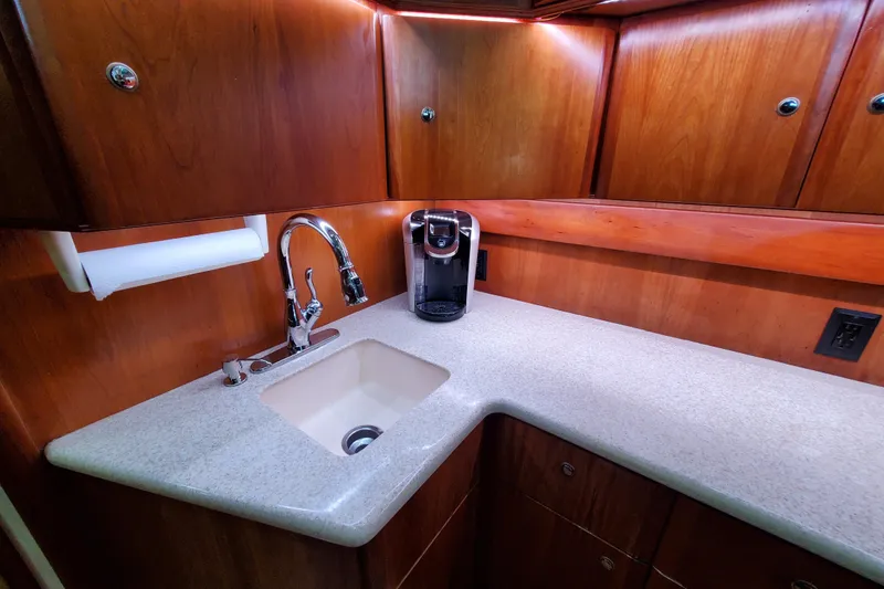 Luxurious kitchen area in a 2000 Silverton 42 Convertible yacht with wooden cabinets and modern fixtures.