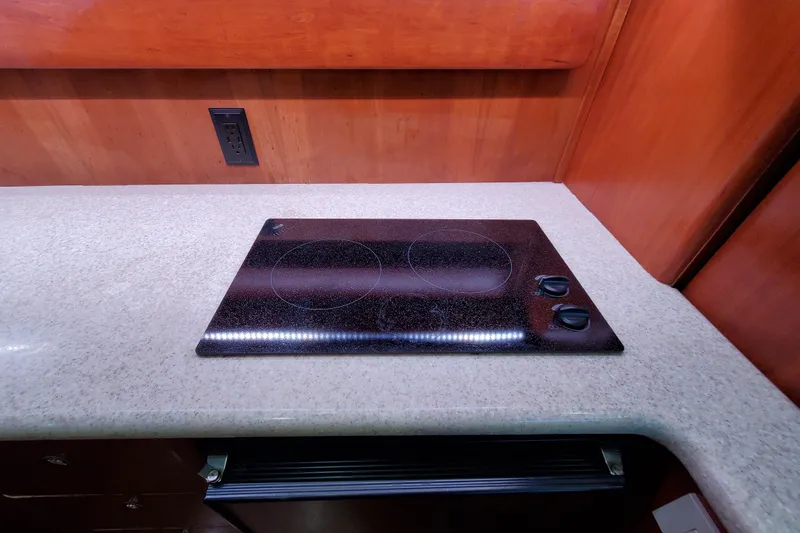 Electric stovetop on a Silverton 42 Convertible yacht, 2000 model, with wooden cabinetry.