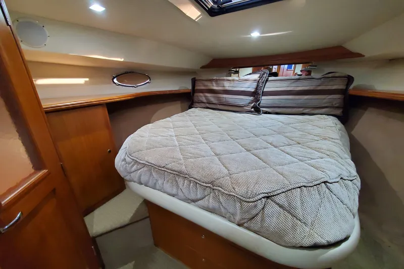 Cozy cabin interior of 2000 Silverton 42 Convertible yacht with plush bedding.