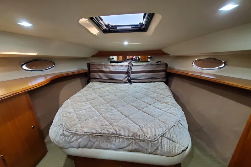 Luxurious cabin interior of a 2000 Silverton 42 Convertible yacht with cozy bedding.