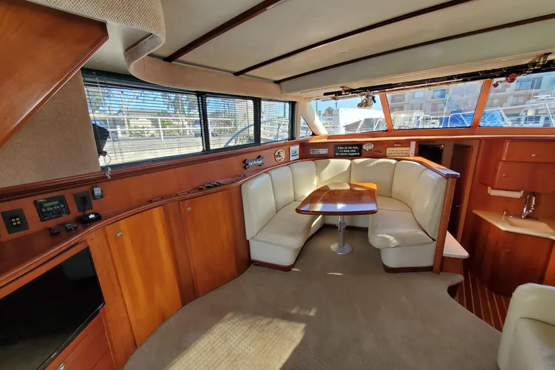 Luxurious interior of 2000 Silverton 42 Convertible yacht with plush seating and wooden finishes.