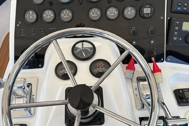 Control panel of a 2000 Silverton 42 Convertible boat with steering wheel and gauges.