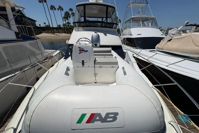 2000 Silverton 42 Convertible yacht docked with inflatable tender on deck.