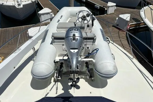 Inflatable dinghy with motor on 2000 Silverton 42 Convertible yacht deck.