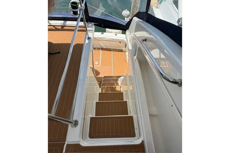 Staircase on 2000 Silverton 42 Convertible yacht with teak flooring and stainless steel railings.