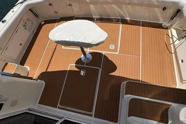 Cockpit of 2000 Silverton 42 Convertible yacht with teak flooring and covered pedestal table.