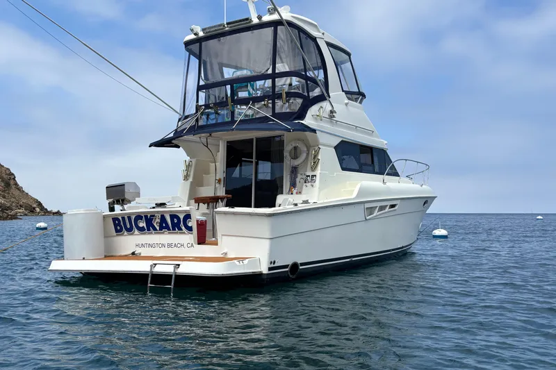 2000 Silverton 42 Convertible yacht anchored in calm waters, Huntington Beach, CA.