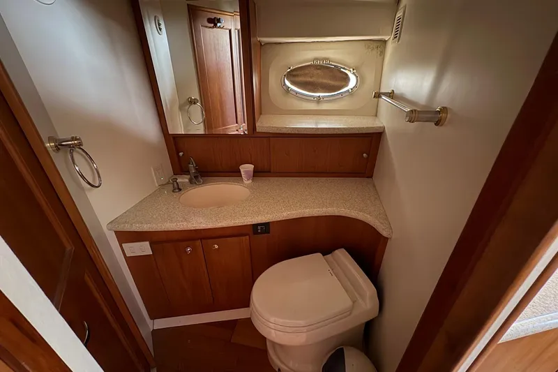 Bathroom interior of 2000 Silverton 42 Convertible yacht with sink and toilet.