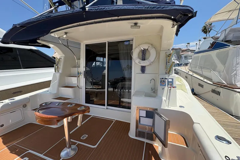 2000 Silverton 42 Convertible yacht deck with seating, table, and sliding glass door.
