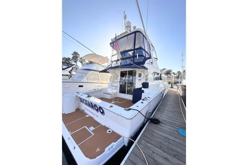 2000 Silverton 42 Convertible yacht docked, featuring spacious deck and sleek design.