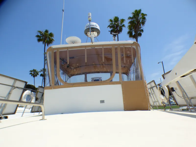 1987 MedYacht Mallorca 50 yacht with enclosed cockpit, palm trees in background.
